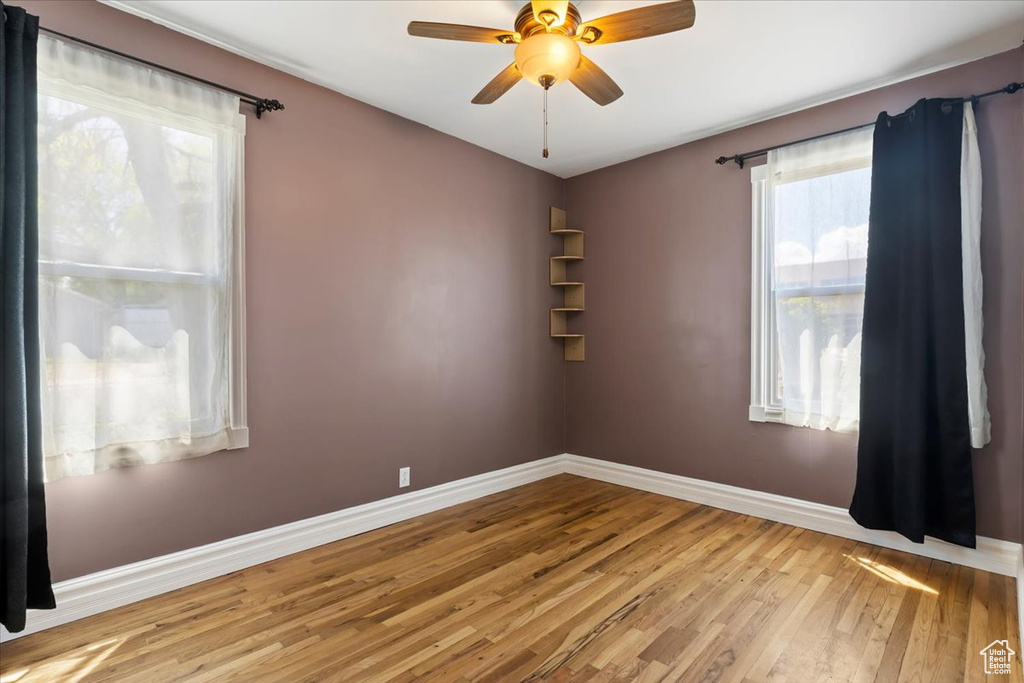Spare room featuring hardwood / wood-style flooring, baseboards, and ceiling fan