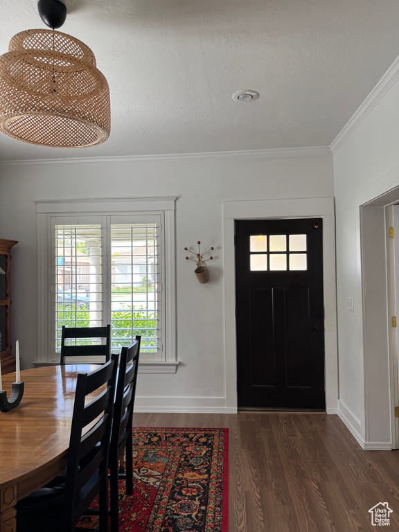 Entrance foyer with wood finished floors, ornamental molding, and baseboards
