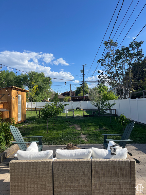 View of patio / terrace featuring an outdoor living space, a storage shed, and an outbuilding