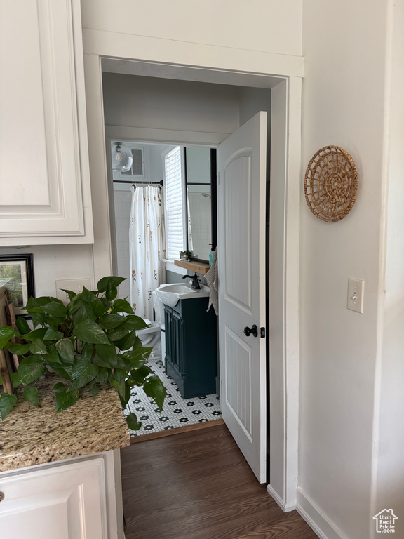 Hallway featuring wood finished floors and baseboards