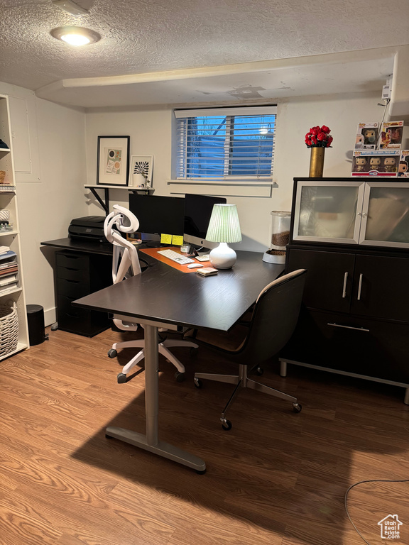Home office with a textured ceiling and wood finished floors