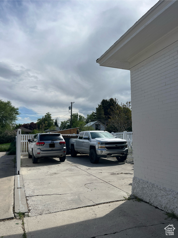 View of car parking with fence and concrete driveway