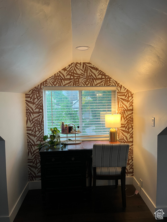 Office area featuring baseboards, wallpapered walls, lofted ceiling, and wood finished floors