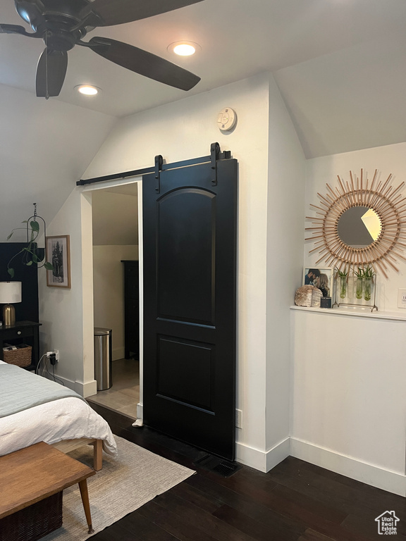 Bedroom featuring a barn door, vaulted ceiling, baseboards, dark wood finished floors, and recessed lighting