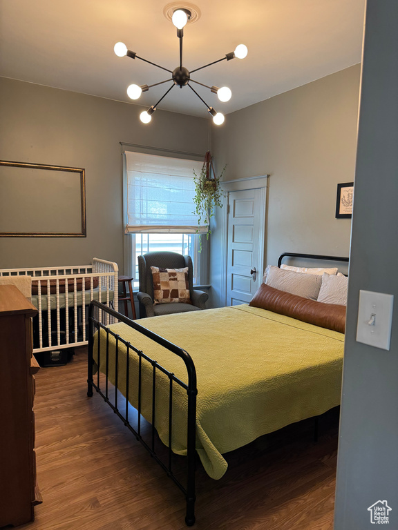 Bedroom featuring wood finished floors and a chandelier