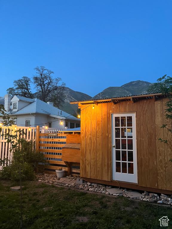 View of outdoor structure featuring fence, a mountain view, and an outdoor structure