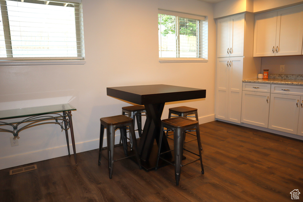Dining room with dark wood-style flooring and baseboards