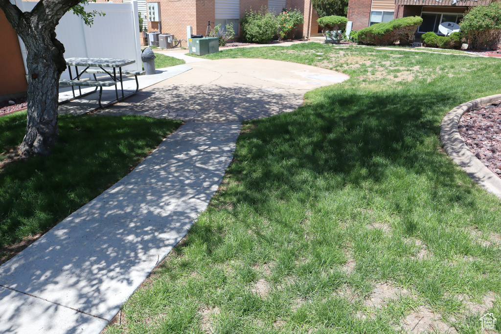 View of grassy yard featuring a patio