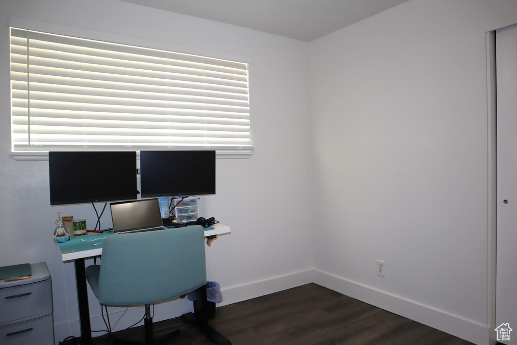 Office area with dark wood-style flooring, baseboards, and plenty of natural light