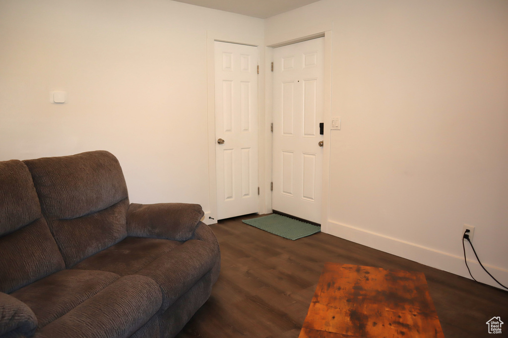 Living area with dark wood-type flooring and baseboards