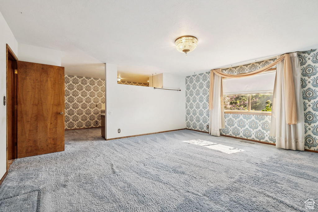 Unfurnished room with carpet floors, wallpapered walls, and baseboards