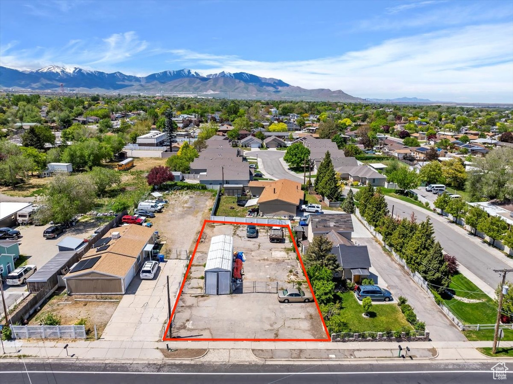 Aerial view of residential area featuring property boundaries highlighted and mountains
