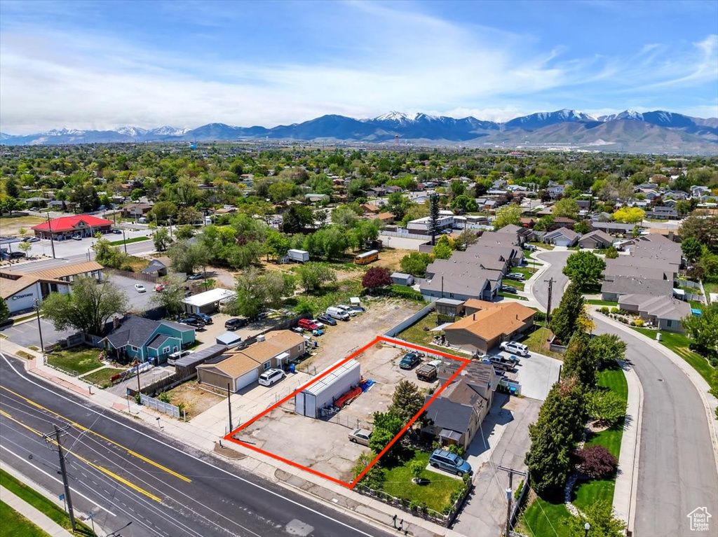 Aerial perspective of suburban area featuring a mountain backdrop and property parcel outlined