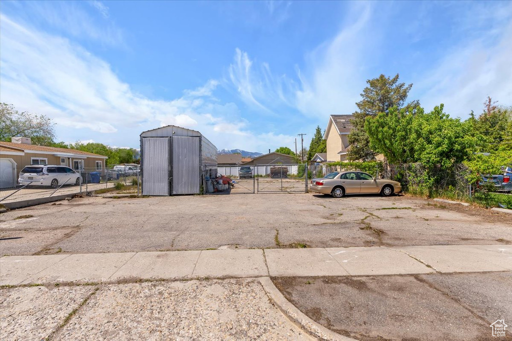 Uncovered parking lot featuring fence, a gate, and a residential view
