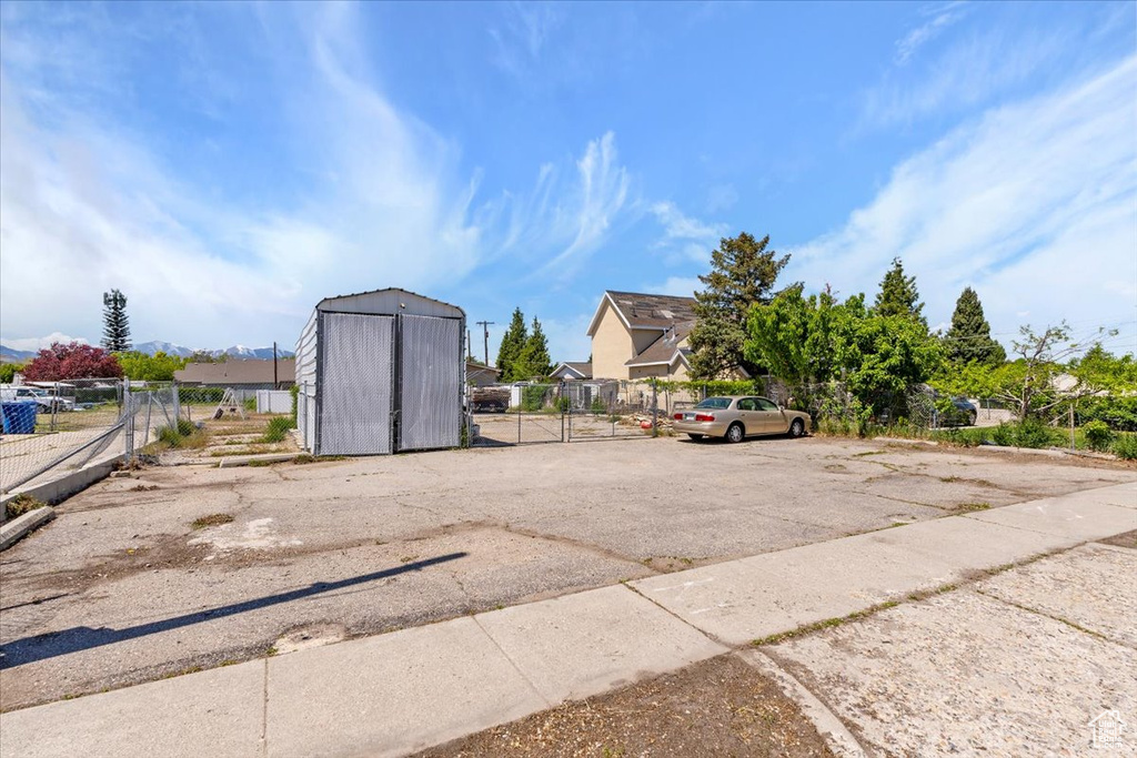 Uncovered parking lot with fence and a storage shed