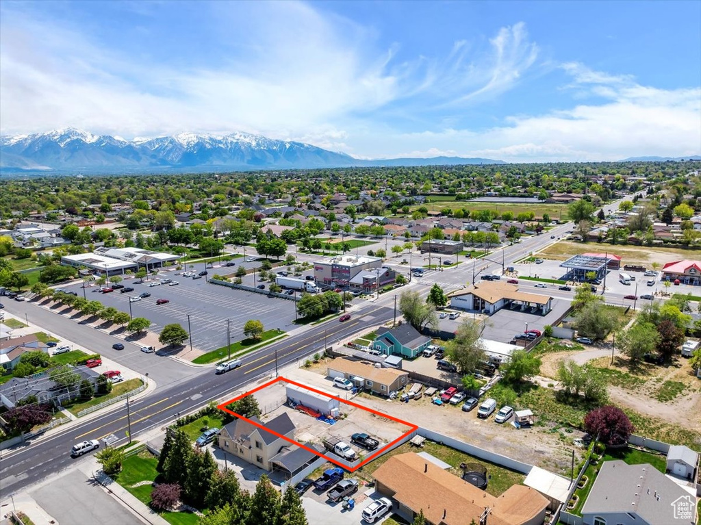 Aerial view of residential area featuring property parcel outlined and a mountain backdrop