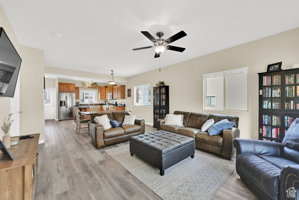 Living room featuring light wood-style floors and a ceiling fan