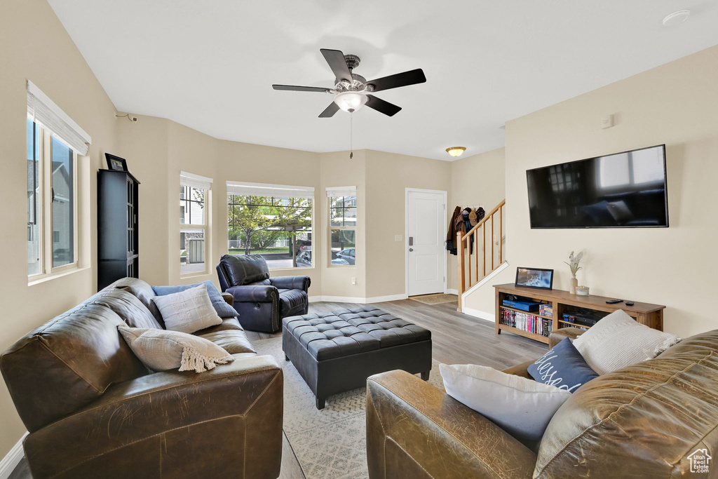 Living room featuring stairway, wood finished floors, ceiling fan, and baseboards