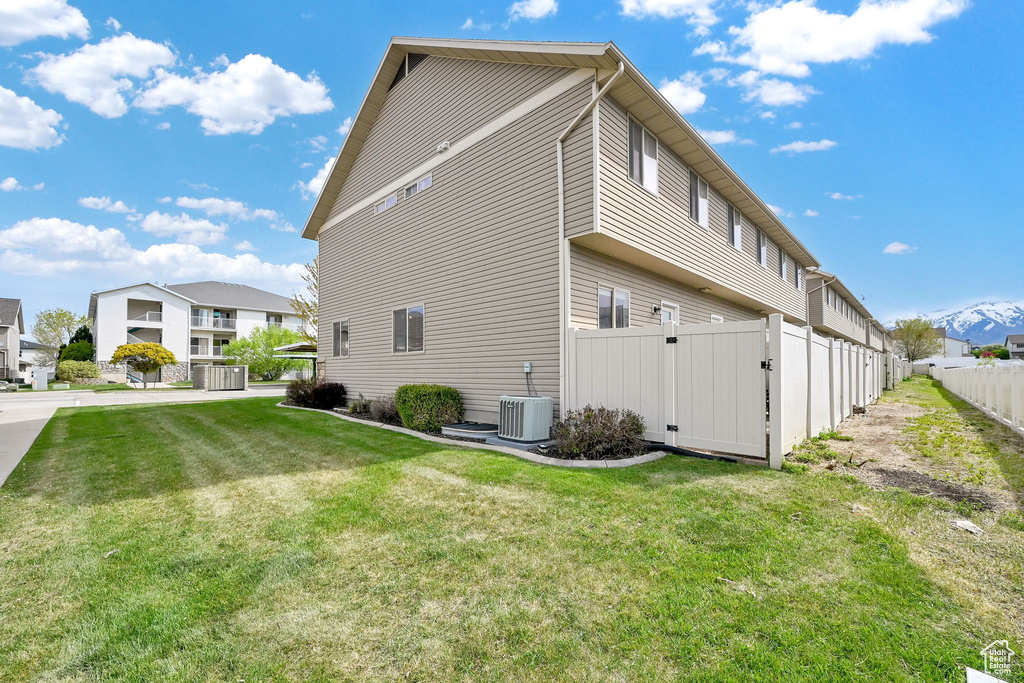 View of side of property with a gate and central AC unit