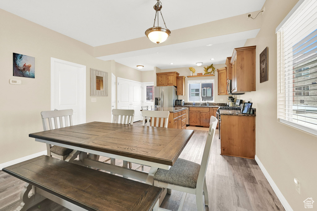 Dining space with plenty of natural light, baseboards, and light wood finished floors