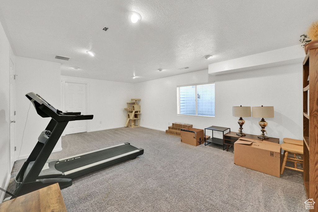 Exercise area with carpet flooring and baseboards