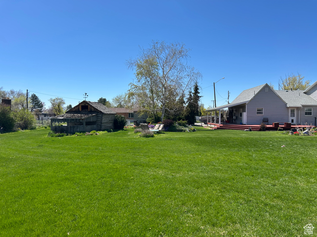 View of grassy yard with a deck