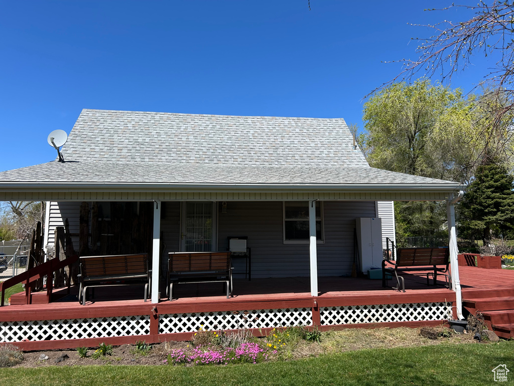 Back of property featuring roof with shingles