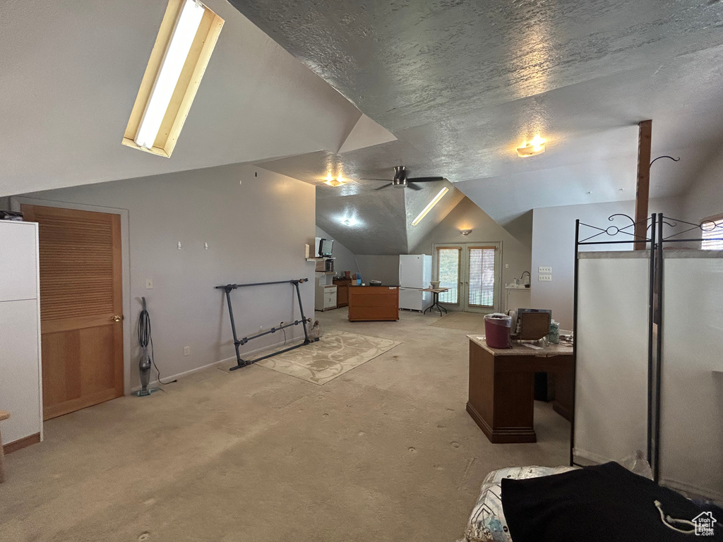 Additional living space with lofted ceiling, light colored carpet, ceiling fan, and baseboards