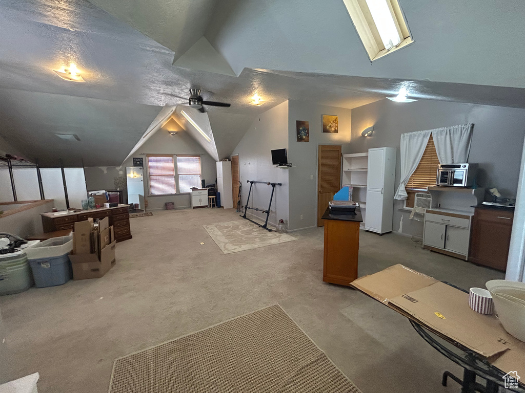 Bonus room featuring lofted ceiling, light carpet, and a ceiling fan