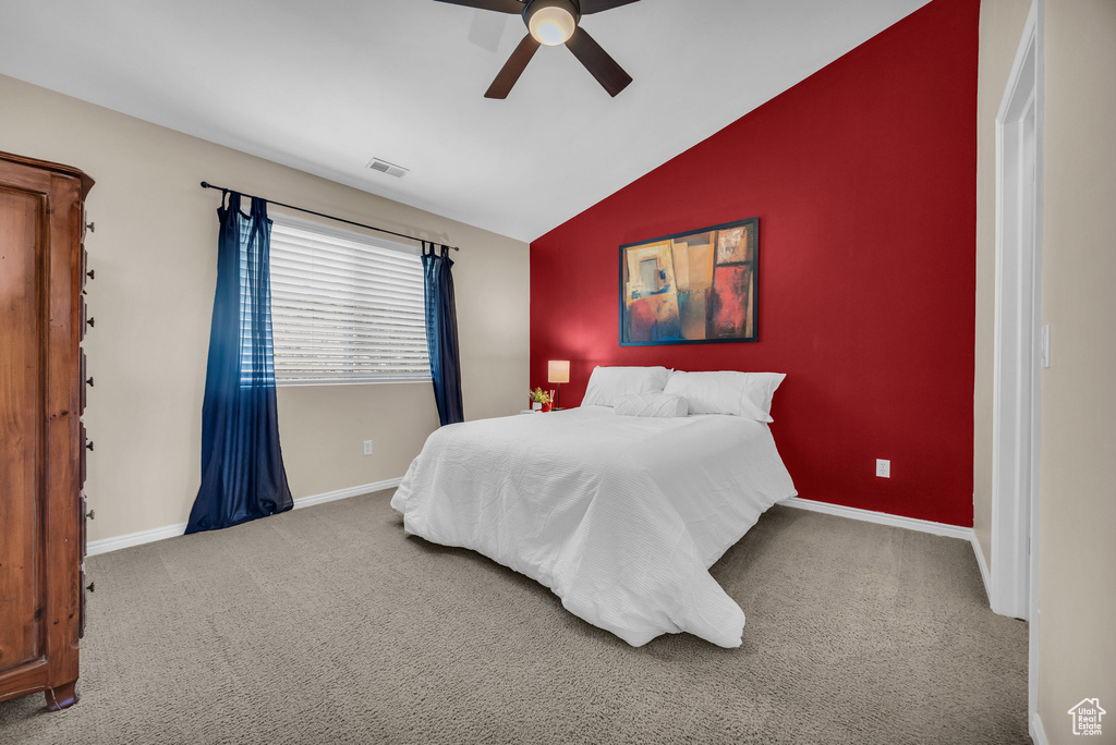 Bedroom featuring vaulted ceiling, carpet flooring, baseboards, and ceiling fan