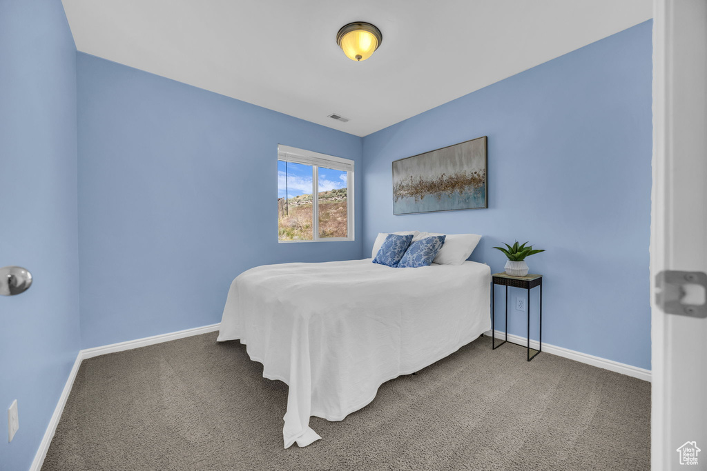 Bedroom featuring carpet and baseboards
