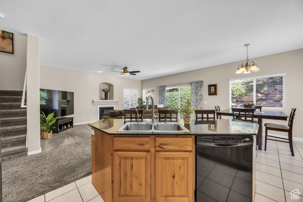 Kitchen featuring dishwasher, a sink, a glass covered fireplace, ceiling fan, and light tile patterned flooring