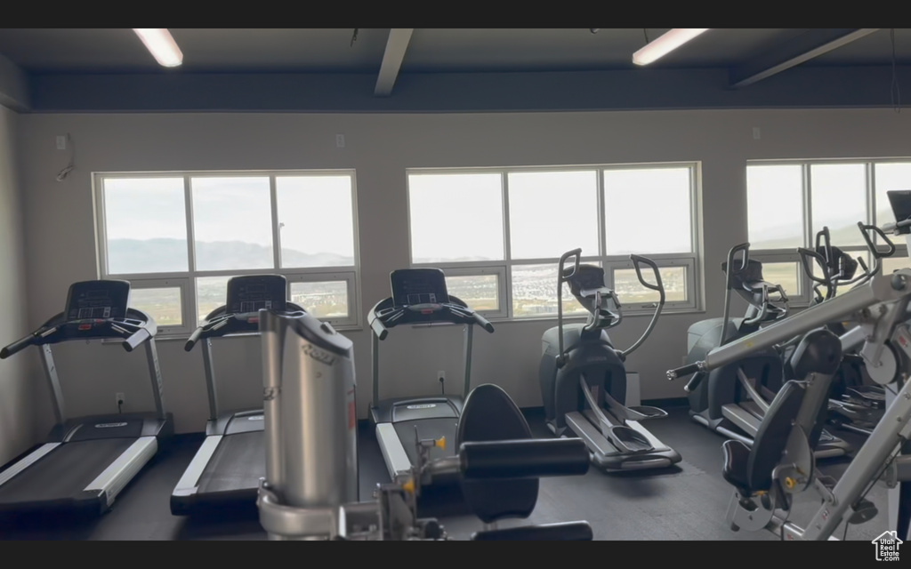 Exercise room featuring beamed ceiling and plenty of natural light