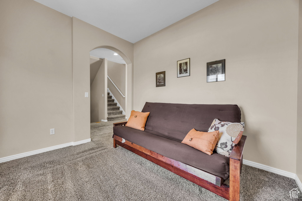 Living area featuring carpet floors, baseboards, and stairway