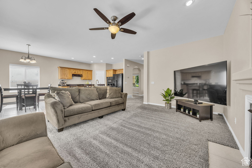 Living area with ceiling fan, arched walkways, a chandelier, baseboards, and recessed lighting