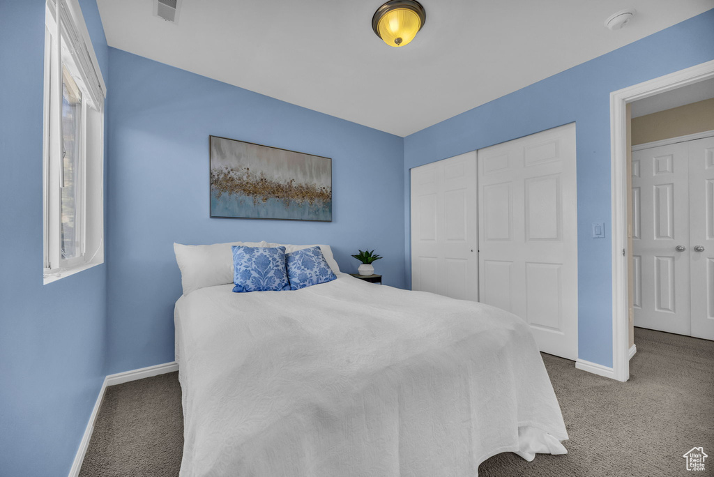 Bedroom featuring carpet flooring, baseboards, and a closet
