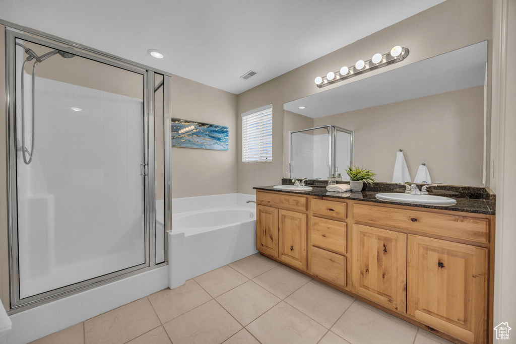 Full bath featuring a stall shower, a garden tub, double vanity, and tile patterned floors