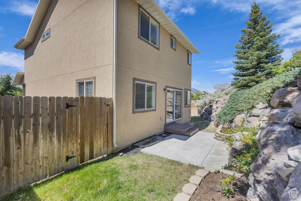 Rear view of house with a patio area and stucco siding
