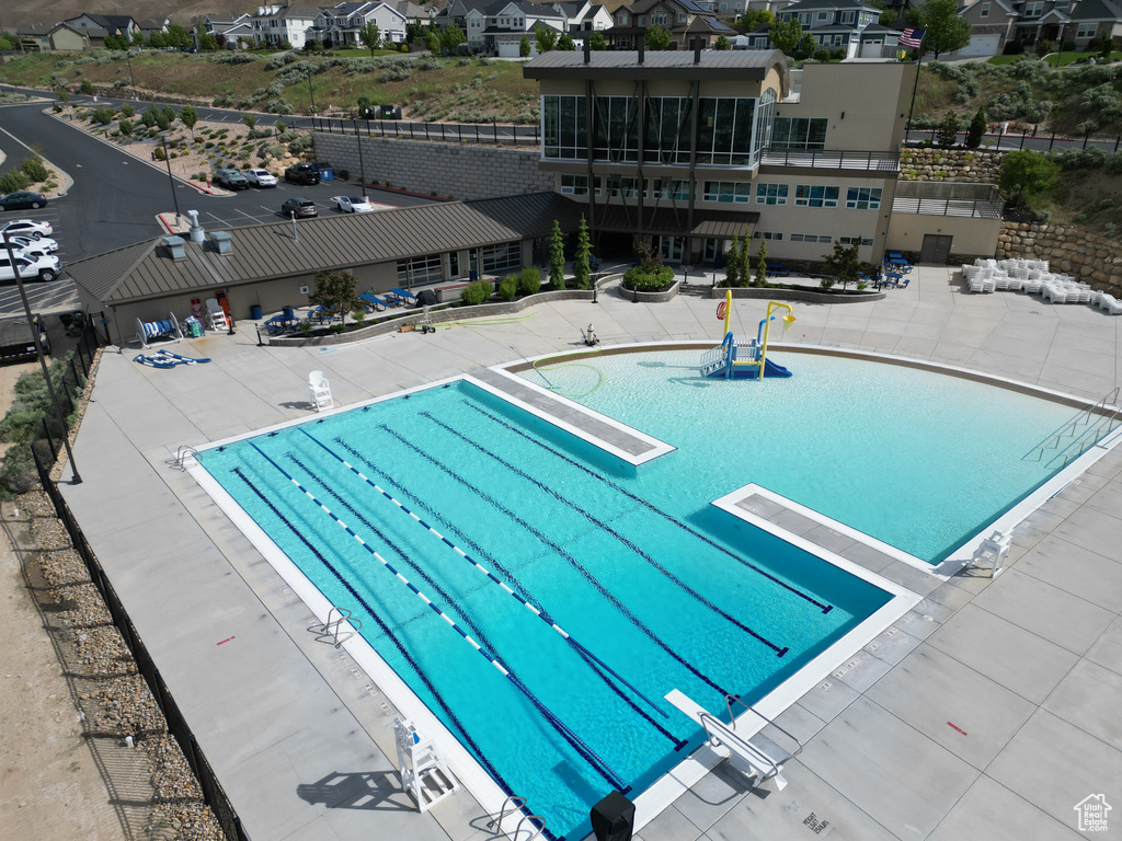 Community pool with a diving board and a residential view