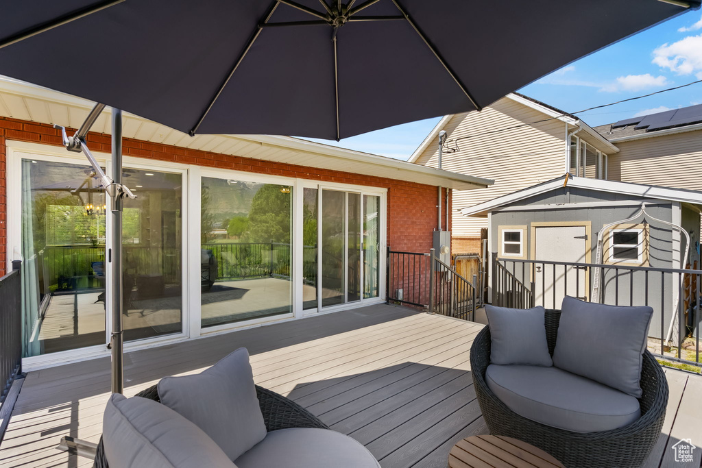 Wooden terrace featuring a storage unit and an outdoor structure