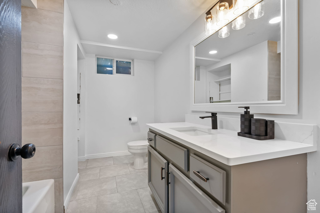 Bathroom featuring vanity, toilet, baseboards, tile patterned flooring, and recessed lighting