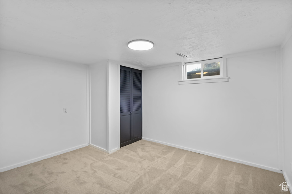 Below grade area with light carpet and baseboards
