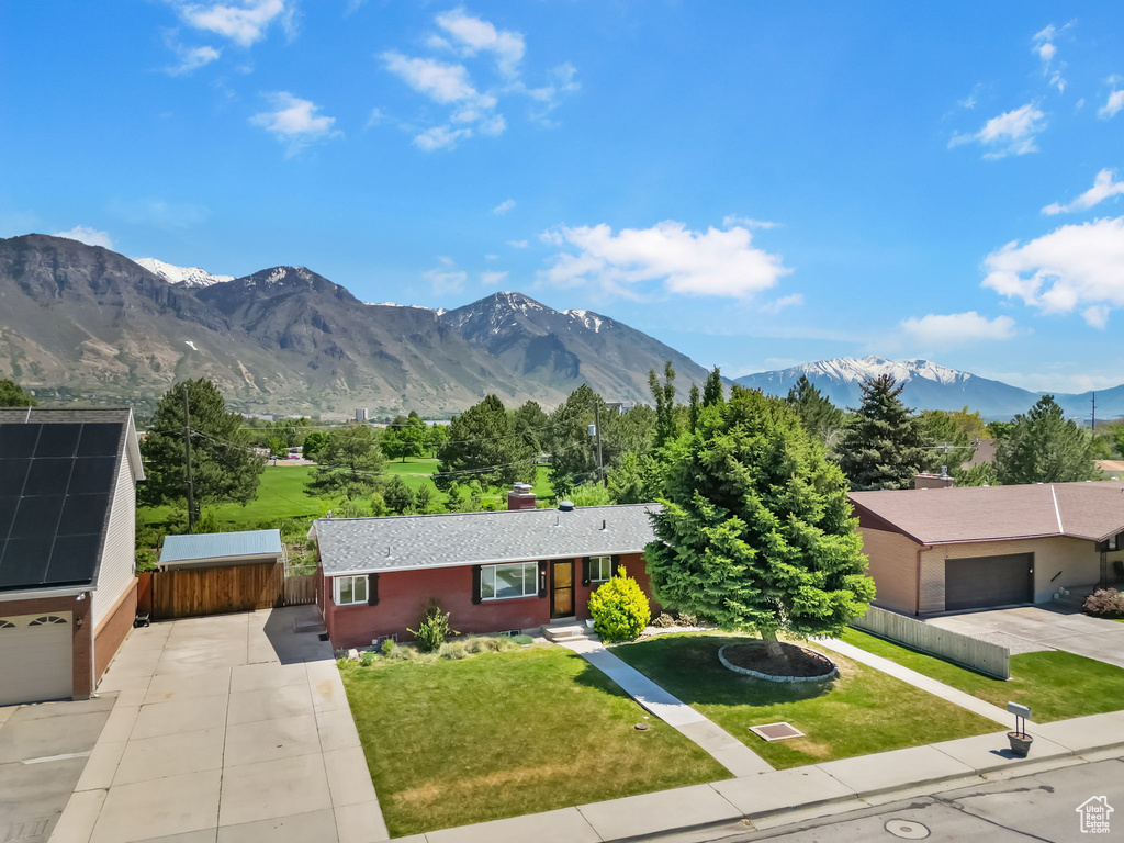 View of front of home featuring a chimney, driveway, and a mountain view