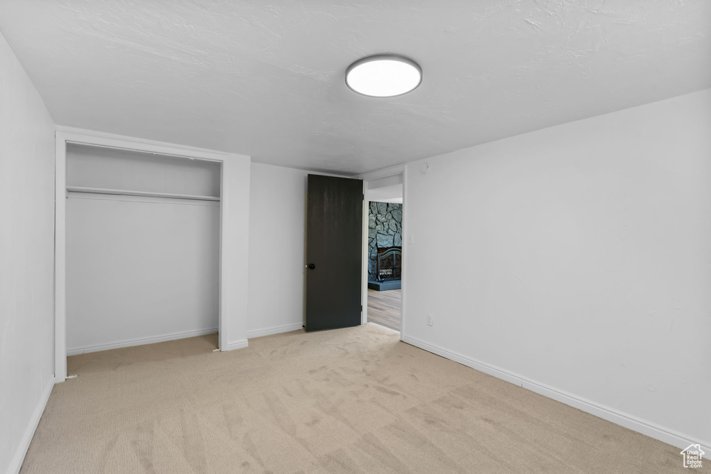 Unfurnished bedroom featuring carpet, a closet, and baseboards