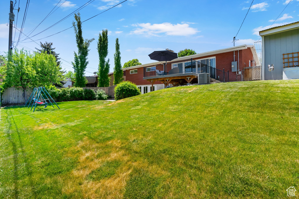 View of yard featuring a deck, cooling unit, and stairway