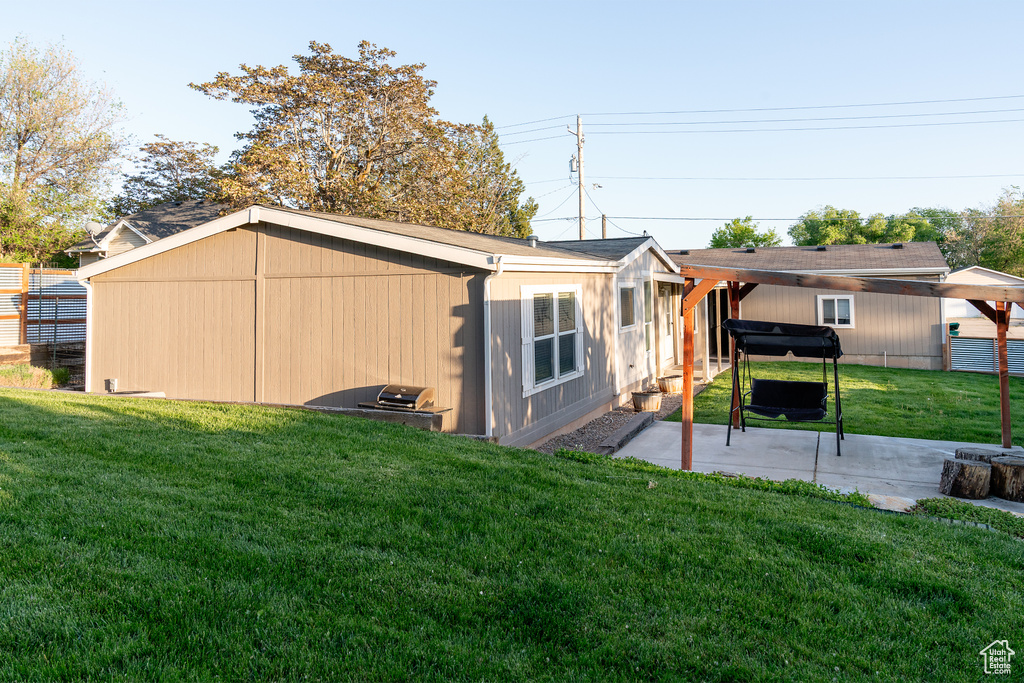 Back of property with a lawn and a patio area