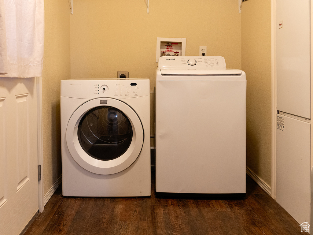 Laundry room featuring dark wood-style floors, a heating unit, and washer and dryer