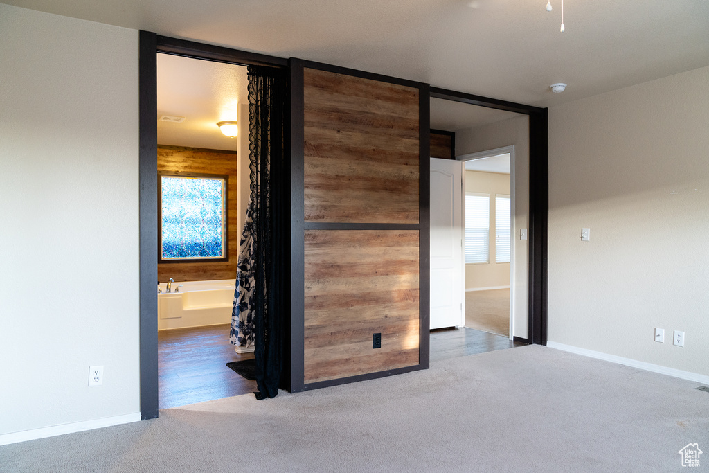 Unfurnished bedroom with carpet, baseboards, and connected bathroom