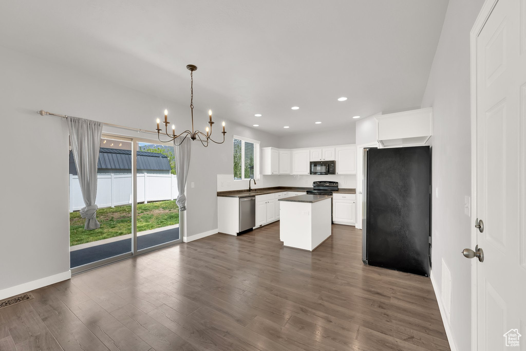 Kitchen featuring black appliances, dark countertops, white cabinets, a chandelier, and dark wood-style flooring