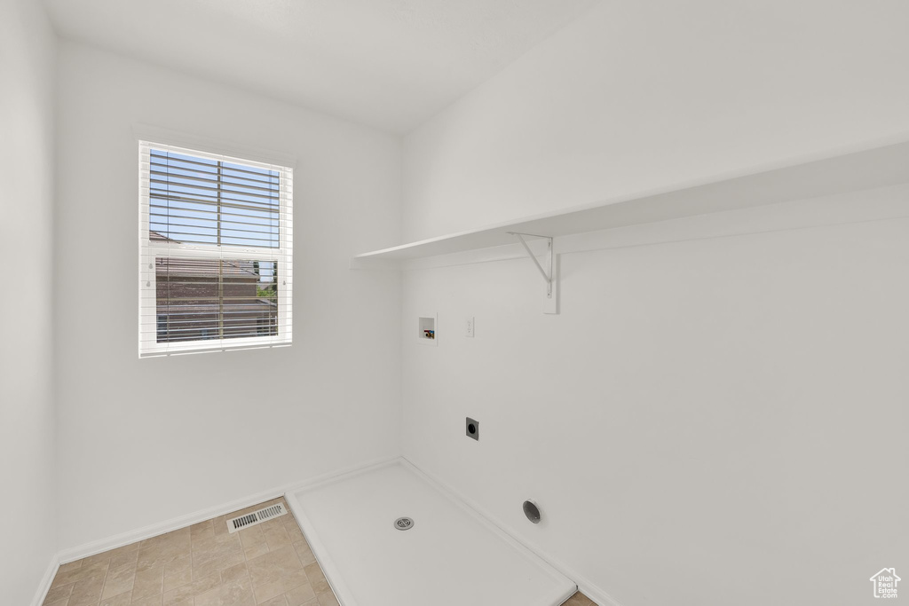 Washroom with electric dryer hookup, washer hookup, and baseboards